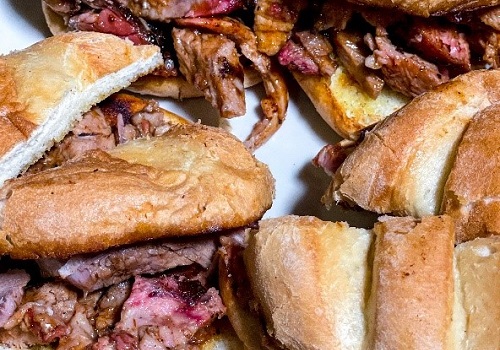 Piles of smoked meats, breads and sides, served by Smokin' Notes BBQ and their Catering Near You